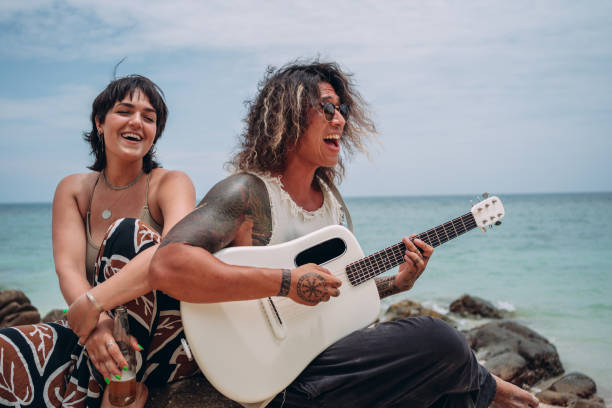 istock Friends singing and playing guitar on the beach 1409010734
