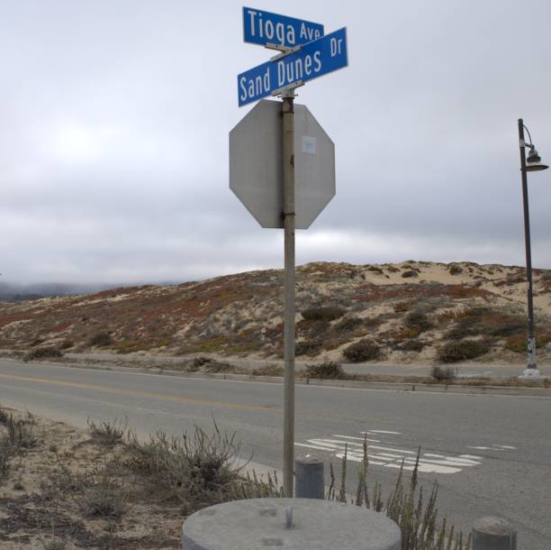 Tioga Ave and Sand Dunes Dr The back of a stop sign at Tioga Ave and Sand Dunes Dr in Sand City, California, USA on a cloudy day with a sand dune in view monterey bay stock pictures, royalty-free photos & images