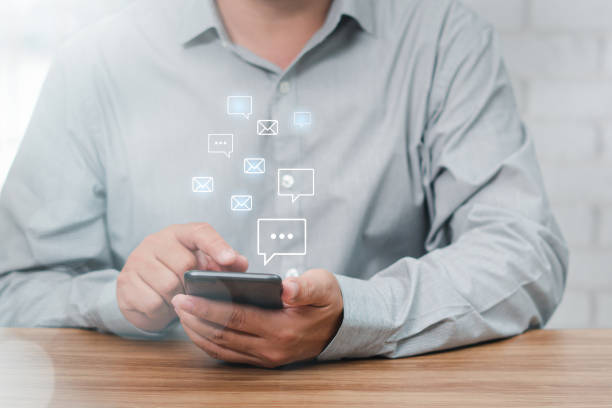 istock Man uses smartphone chat and send messages in a conversation, the house is set against a white brick wall backdrop and virtual screen icon concept 1409023036