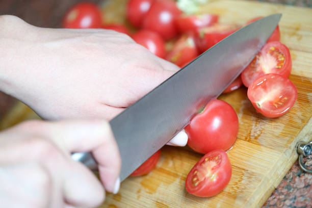 istock Chef is cutting tomatoes in kitchen and vegetarianism 1409025870