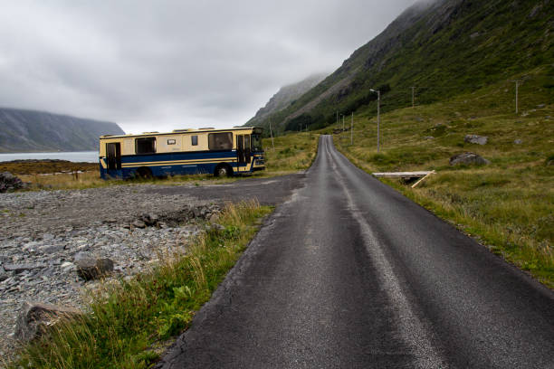 an old empty wracked bus standing next to astraight narrow street