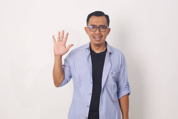 istock Young asian man smiling cheerful showing number five with fingers. 1409034136