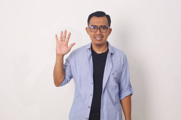 istock Young asian man smiling cheerful showing number five with fingers. 1409034140
