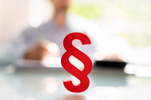 Close-up Of A Red Paragraph Symbol In Front Of Person Working At Workplace