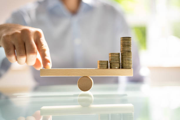 istock Businessman Balancing Stacked Coins With Finger 1409041195