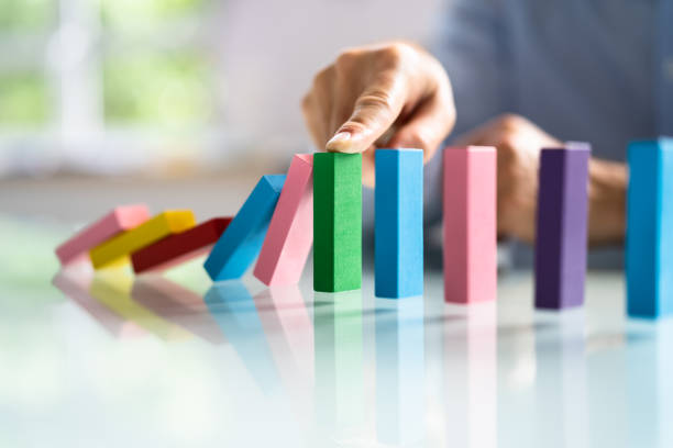 istock Businessperson Hand Stopping Colorful Blocks From Falling 1409041200
