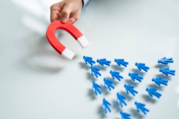 istock Hand Attracting Human Figures With Horseshoe Magnet 1409041234