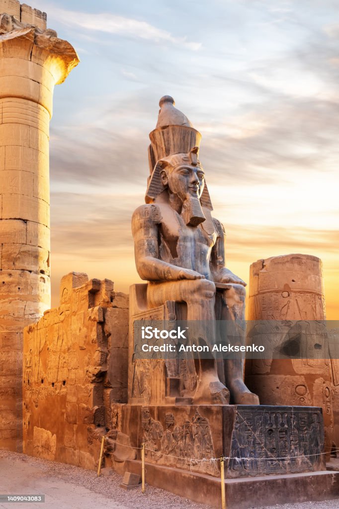 Seated statue of Ramesses II by the Luxor Temple entrance, sunset scenery, Egypt Seated statue of Ramesses II by the Luxor Temple entrance, sunset scenery, Egypt. Egypt Stock Photo