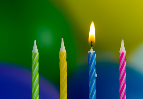 Colorful birthday candles with balloons background