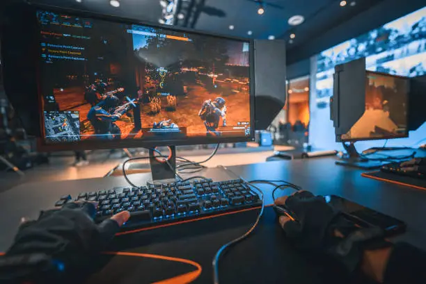 Photo of first person view asian esports team player playing shooting game with his teammates in grand final esport arena with live broadcasting against other team