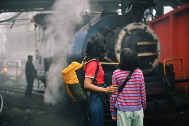 istock Mother and daughter looking at a steam train 1409049827