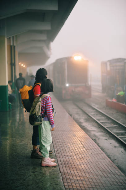 istock Mother and daughter waiting at a train station platform 1409049944