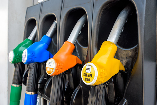 France - June 19, 2022: Close-up view of a four nozzle fuel pump at a gas station dispensing B10 Diesel (yellow), B7 Diesel (orange), E85 super ethanol petrol (blue) and E10 petrol (green).