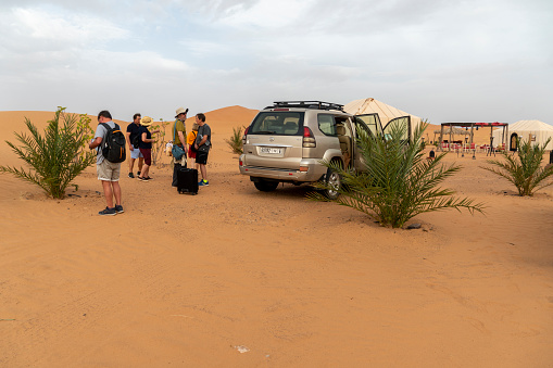Merzouga Morocco on May 28, 2022 Berber camp at Tiziri  Luxury resort in the desert. Tourists and jeep leaving the spot.