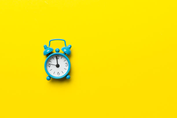 istock Alarm clock isolated on colored background with copy space top view 1409054910