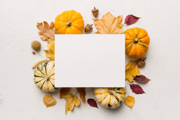 istock Autumn composition with paper blank and dried leaves with pumpkin on table. Flat lay, top view, copy space 1409054935