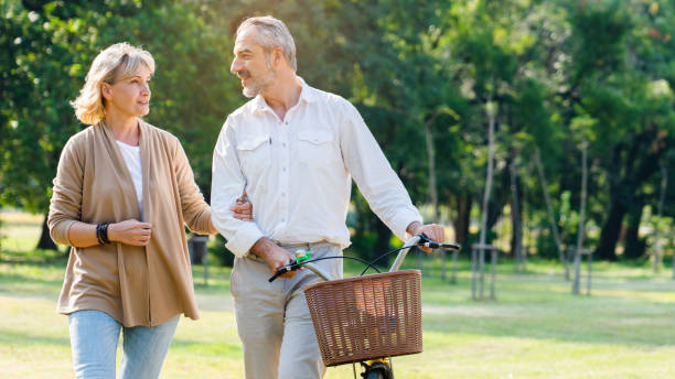 Senior Caucasian couple hugging in park. Family with a happy smile feels relaxed with nature in the morning. Or in the evening. Enter elderly society And retire from work. Concept health insurance stock photo