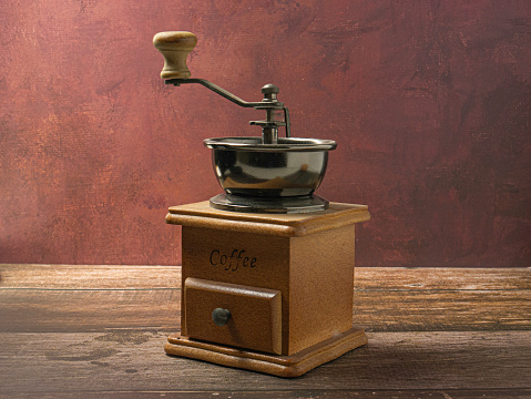 an old wooden grinder with grains of coffee
