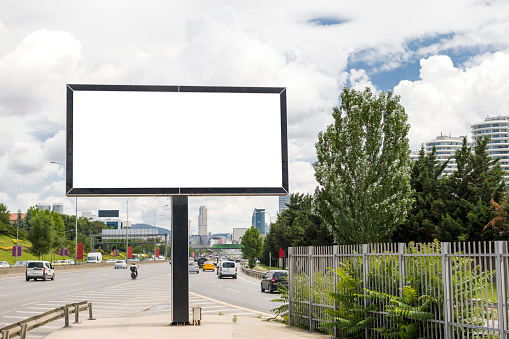 Horizontal blank billboard on the city street in background buildings and road with cars mock up