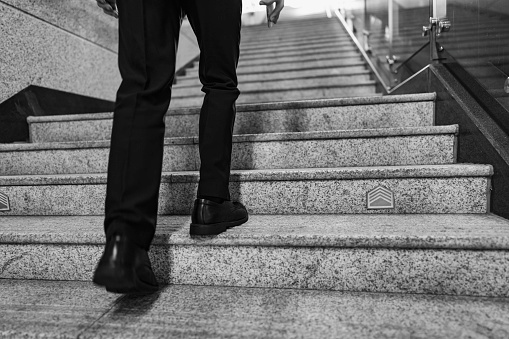 Close-up of feet of business man walking up stairs