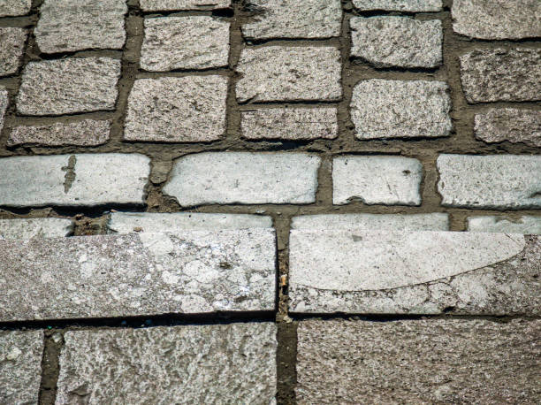 istock Background texture of tiled stone road. Grey rough bricks. 1409069501