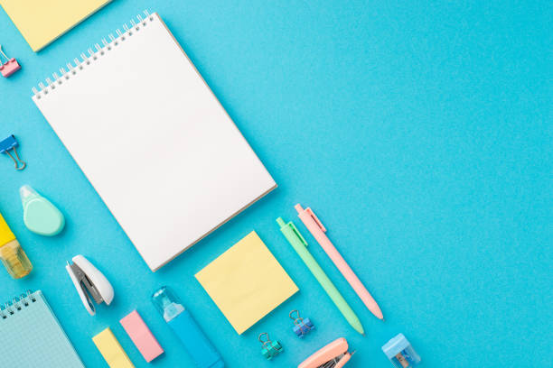 istock Back to school concept. Top view photo of ordered stationery open spiral notepad sharpener binder clips correction pens eraser stapler paper sticky notes on isolated blue background with blank space 1409071110