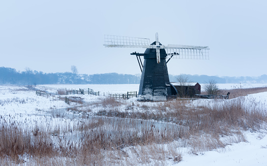 Snowy morning at Herringfleet Mill. Snowy reeds and frozen creek with windmill i - Herringfleet March, 2018