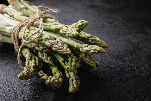 istock Green asparagus on a black background 1409074303