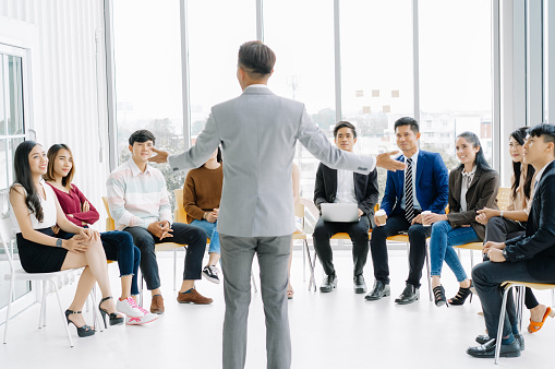 Serious business man team leader coach mentor talk to multiethnic staff in modern office explain strategy at corporate group meeting, On job training. Learning Coaching Business Concept