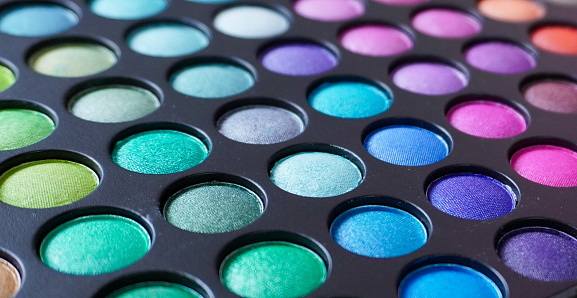 A closeup shot of a colorful eyeshadow palette with glittery circles
