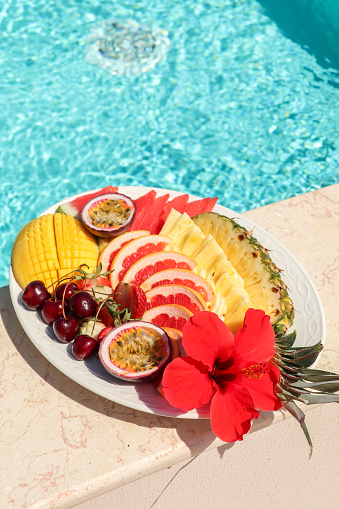 tropical fruit platter snack by the pool with pineapple and mango