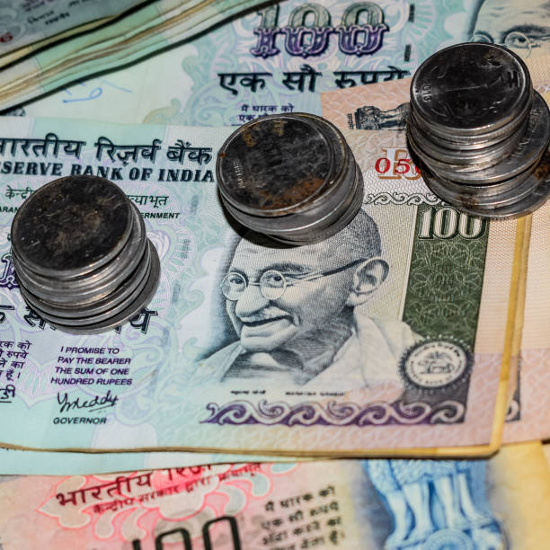 istock Rare Old Indian bank rupee coins falling on currency notes, Falling down Indian rupee coin on one hundred rupees notes, Indian Currency Coins falling 1409083860