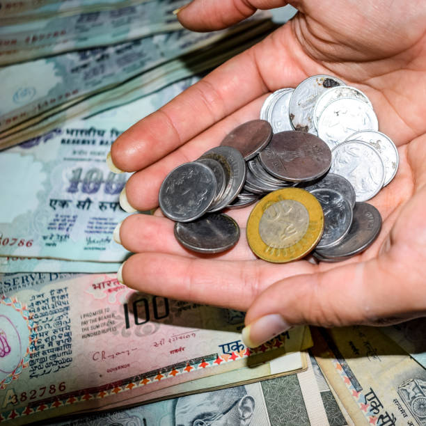 istock Rare Old Indian bank rupee coins falling on currency notes, Falling down Indian rupee coin on one hundred rupees notes, Indian Currency Coins falling 1409083861