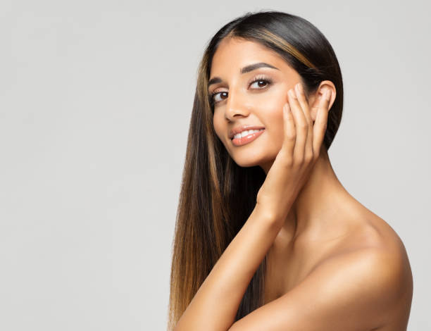 retrato de rostro de mujer joven. modelo de belleza tocando pómulos. cuidado de la piel facial de las mujeres y tratamiento de estiramiento facial sobre fondo blanco. chica de moda sonriente con maquillaje suave - mejilla fotografías e imágenes de stock