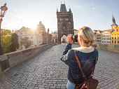 Young woman photographing the city of Prague with camera