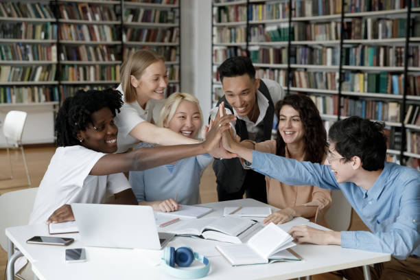 Group of six multinational cheerful students giving high five