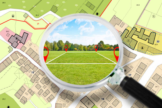Searching a free Land plot with a vacant land available for building construction - Concept seen through a magnifying glass - note: the map is totally invented and does not represent any real place stock photo