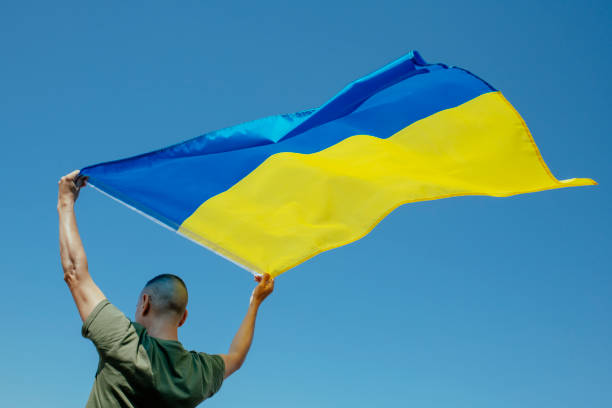 istock man waving the ukrainian flag on the sky 1409088038
