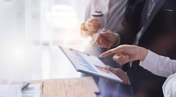 istock Financial analysts analyze business financial reports on a digital tablet planning investment project during a discussion at a meeting of corporate showing the results of their successful teamwork. 1409088150