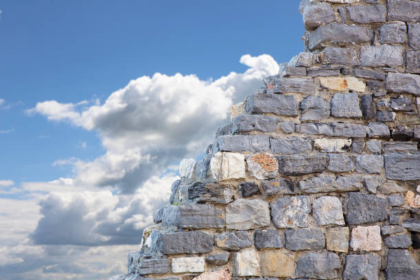 Stone wall with large stone blocks against a sky background - concept image with copy space
