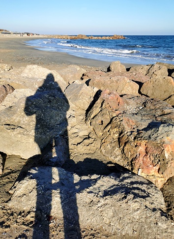 My shadow in the sea. Sunny day in autumn.