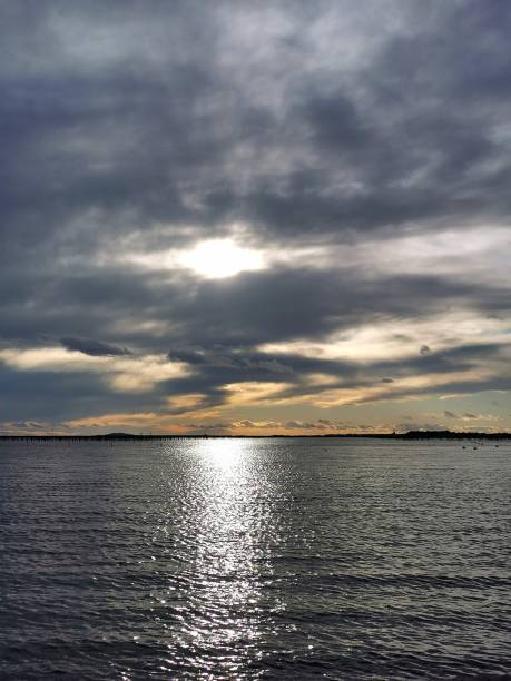 istock Reflection of sunlight on sea water, with threatening winter sky 1409093086