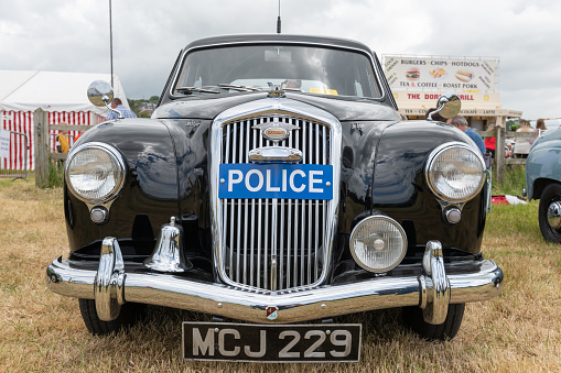 West Bay.Dorset.United Kingdom.June 12th 2022.A vintage Wolseley police car is on display at the West Bay vintage rally