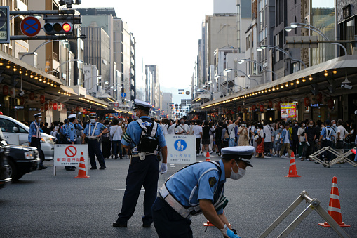 Kyoto, Japan - July 16, 2022: Police set up barriers at the intersection of Shijo and Kawaramachi streets to create a \