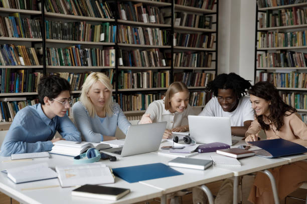 istock Group of multiethnic students studying together in library using laptop 1409098788