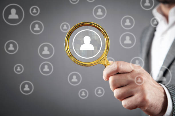 istock Man showing magnifying glass with a human symbols. Human Resources 1409100089