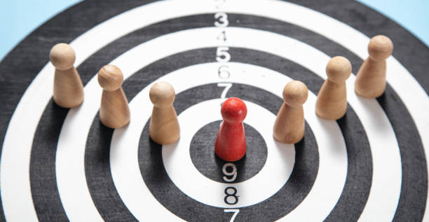 istock Wooden human figures on target dartboard. Target. Success. Business 1409100110