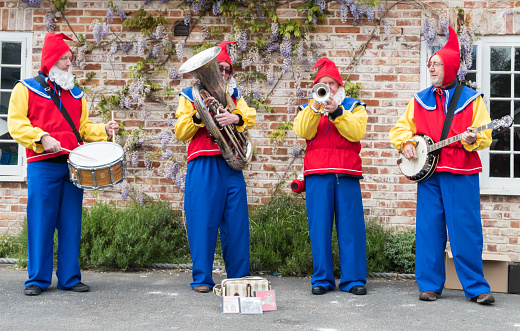 Downton, UK - 29 April 2017: Folk band dressed as garden gnomes entertain the crowds at the annual Cuckoo Fair in Downton, Wiltshire