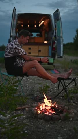 Homem aproveita café e relaxa perto do fogo