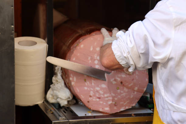 pessoa em atividade corta grande fatia mortadela - salumeria - fotografias e filmes do acervo